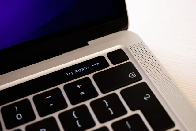 High-resolution close-up of a laptop keyboard featuring a 'Try Again' button. What to check when cloud files are missing or sync is stuck