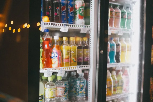 Assorted bottles of soft drinks in a commercial refrigerator with glass doors. How Long Can a Portable Power Station Run a Fridge? Real Runtime Math