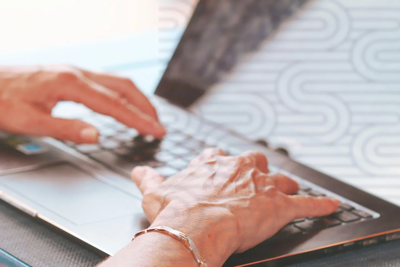 hands typing, elderly hands, typing on laptop, working on computer, female hands, silver bracelet, remote work, technology, digital work, online communication, freelance job, senio