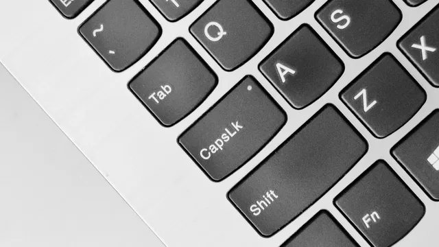 A detailed close-up of a laptop keyboard highlighting the Caps Lock and Shift keys. How to set up accessibility features safely