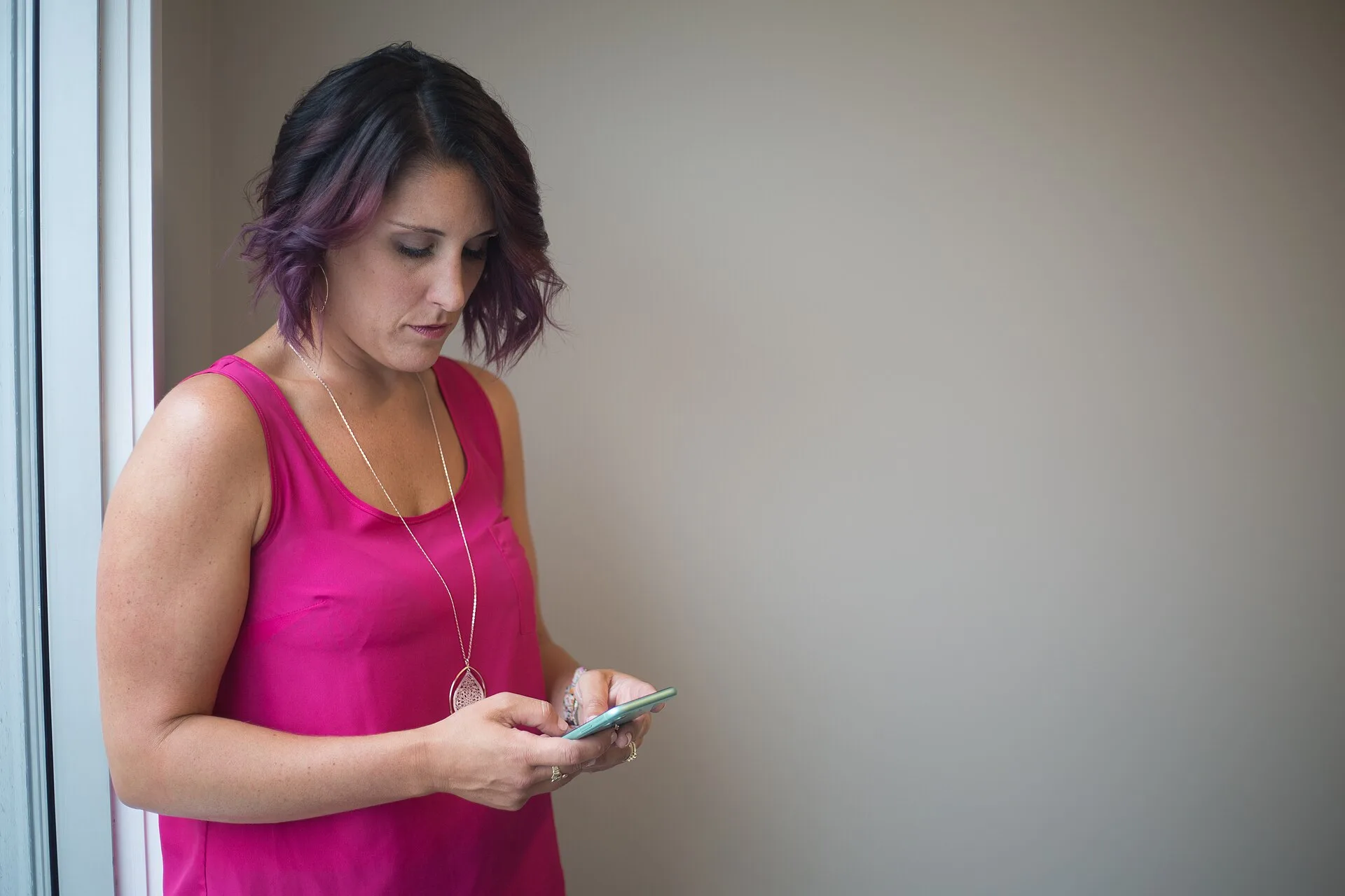Woman texting on a smartphone. Reading smartphone basics with a sceptical eye