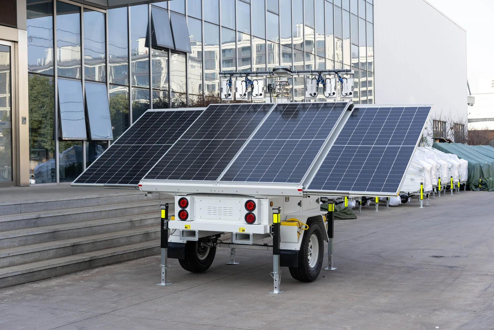 A mobile solar panel trailer parked outdoors by a modern building, showcasing renewable energy technology. Solar Generator vs Portable Power Station: What Actually Backs Up Your Home?
