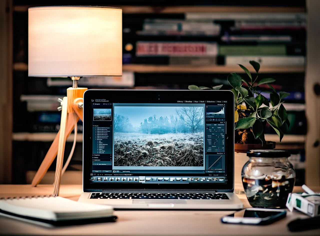 An open laptop displaying photo-editing software on a desk